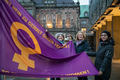 Bettina Wilhelm, Antje Grotheer und die Abgeordnete Gönül Bredehorst stehen vor dem Haus der Bürgerschaft und halten gemeinsam die Flagge in der Hand.