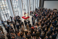 Präsidentin steht am Rednerpult im Festsaal, die Gäste hören ihr zu.