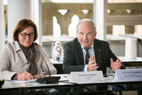Per Thöresson und die Ausschuss-Vorsitzende Susanne Grobien sitzen nebeneinander an einem Tisch im Sitzungsraum, während der Botschafter zu den Abgeordneten spricht.