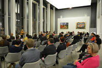 Vizepräsidentin Silvia Schön eröffnet die Ausstellung Fotografie der Vizepräsidentin am Rednerpult vor dem Publikum