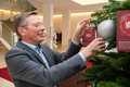 Frank Imhoff hängt Wunschzettel an einen geschmückten Tannenbaum im Foyer der Bürgerschaft.