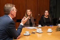 Frank Imhoff sitzt am Besprechungstisch in seinem Büro und spricht mit Dr. Parissa Fathi sowie Shayda Oghapanjeh, der Mutter des Inhaftierten.