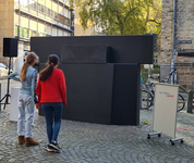 zwei Schülerinnen betrachten das schwarze Mahnmal für die Opfer der Reichspogromnacht in Bremen