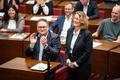 Antje Grotheer steht am Mikrofon im Plenum und lächelt. Die um sie herum sitzenden Abgeordneten applaudieren.