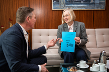 Dr. Sommer und Frank Imhoff sitzen sich in der Sitzgruppe im Präsidentenzimmer schräg gegenüber. Dr. Sommer hält den Bericht in ihren Händen. Auf dem Couchtisch zwischen beiden stehen Kaffeetassen.