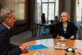 Dr. Imke Sommer sitzt am Konferenztisch im Präsidentenzimmer und spricht mit Hans-Joachim von Wachter, der ihr schräg gegenüber sitzt. Zwischen den beiden liegt der Bericht mit blauem Cover.