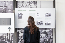 Eine Frau in dunkler Kleidung betrachtet die Ausstellung.